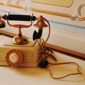 A classic vintage rotary phone with ornate details on a decorative table, conveying retro charm.