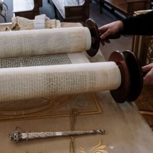 Torah scrolls and yad on synagogue table, highlighting Jewish tradition.